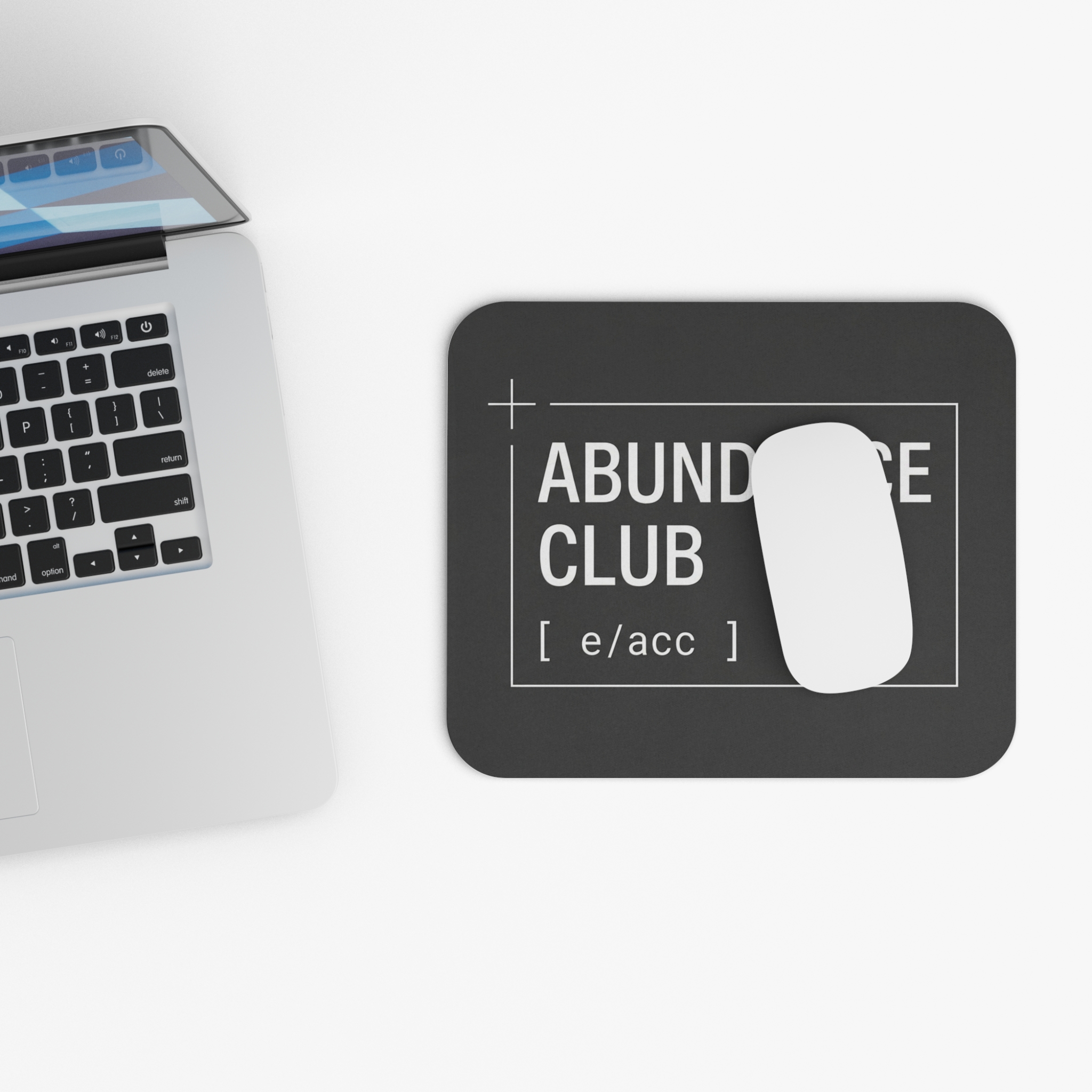 Abundance Club Mouse Pad on a desk with laptop.